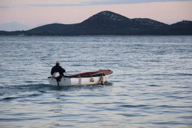 Fisherman in boat on sea