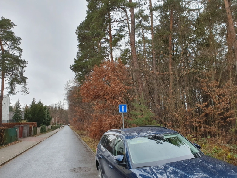 Lesní cesta s autem a dopravním značením v Klánovickém lese.