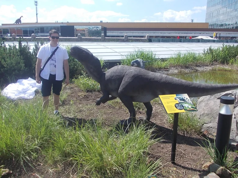Model dinosaura v expozici s návštěvníkem venku