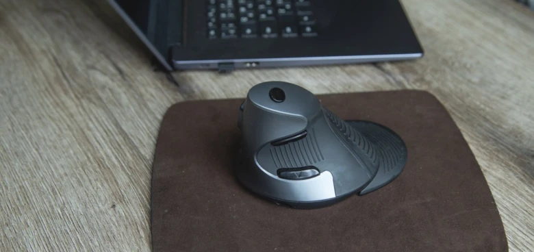 Ergonomická myš s kulíčkou na pracovním stole.