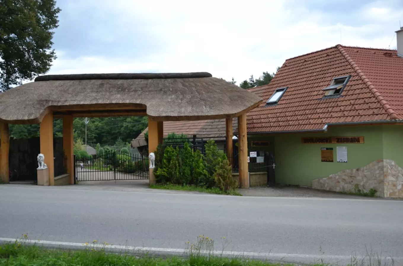 Vstupní brána zoologické zahrady s trámovou střechou.